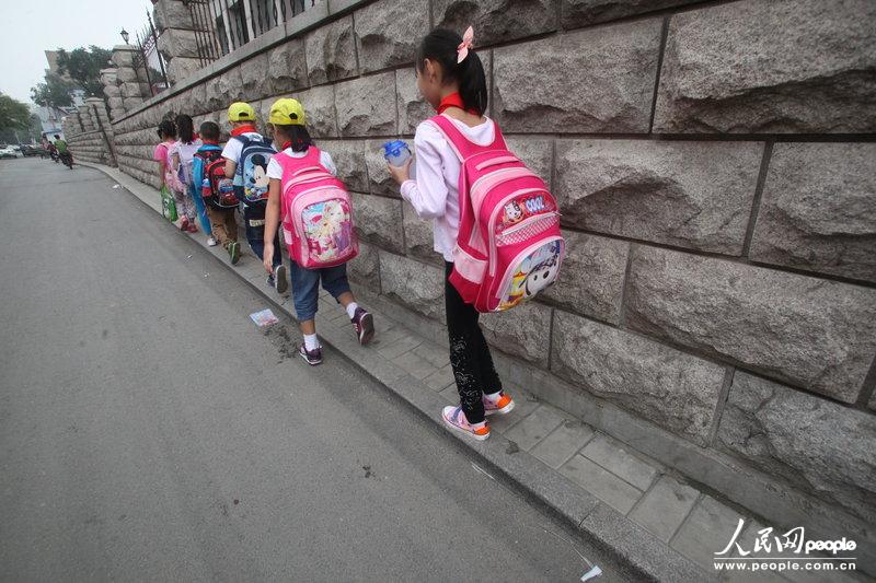 2013年09月11日，濟南運署街上，小學(xué)生走史上“最窄人行道”上學(xué)。