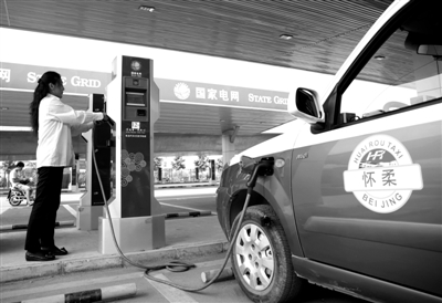 9月11日，懷柔區(qū)，電動(dòng)出租車司機(jī)正在為車輛充電。
