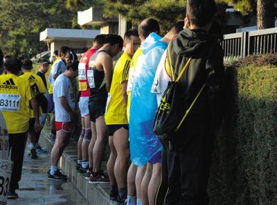 2013年10月20日，北京馬拉松比賽，由于廁位有限，一些選手在綠化帶“就地解決”。圖/IC