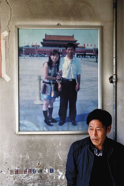 11月14日，承德市平泉縣，潘小梅父母的家，潘小梅父親靠在墻上，身后掛著數(shù)年前他和潘小梅在北京的合影照片。新京報(bào)記者