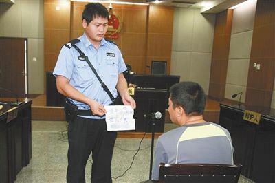 昨日庭審中，法警向趙某出示其扎完車胎后所留辱罵公司的紙條。通訊員 李秀文 攝