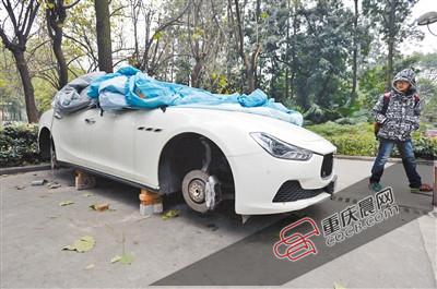 昨日，停放在重慶大學(xué)B區(qū)的一輛瑪莎拉蒂豪車被架在幾塊磚頭上，車輪不翼而飛。 重慶晨報(bào)記者 胡杰 攝