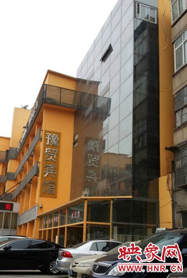 該酒店為加蓋樓層統(tǒng)一安裝上黑色玻璃，從前面看不出加蓋的痕跡