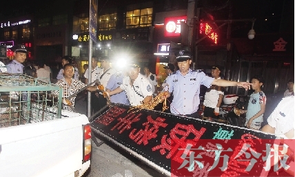 7月8日晚，鄭州市商城路一家占道經(jīng)營(yíng)的攤販招牌被執(zhí)法隊(duì)員“登記保存”