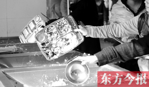 11月27日，河南中醫(yī)學(xué)院餐廳，一名同學(xué)將餐盤內(nèi)沒吃完的食物倒入餐具回收車內(nèi)