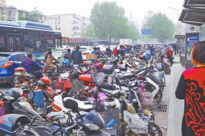 省人民醫(yī)院北門，路邊的公交站牌處停滿非機動車，上、下客只能在快車道上。