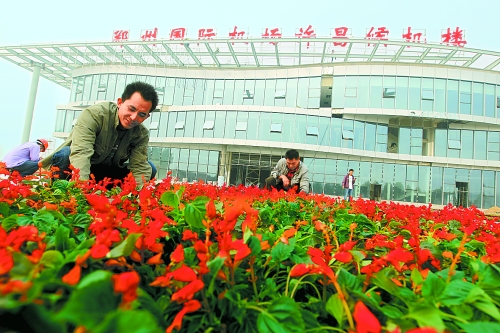 9月23日，工人們正在鄭州國際機(jī)場許昌候機(jī)樓前擺放鮮花。