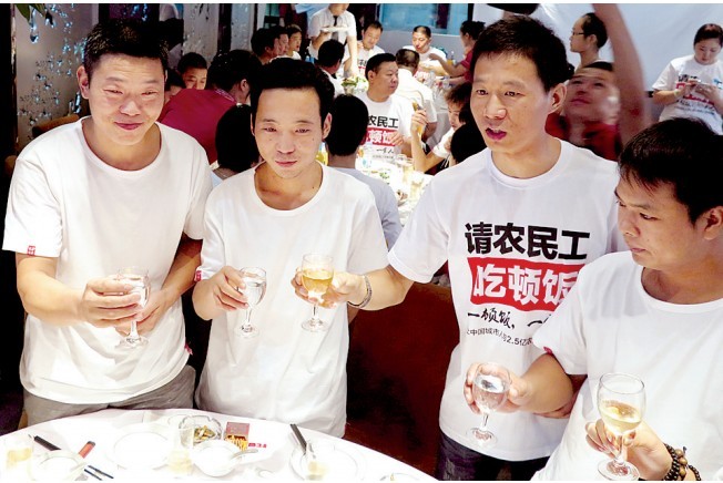 活動發(fā)起人張楠（右二）給農(nóng)民工敬酒。