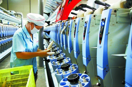 7月3日，在鄧州市永泰棉紡有限公司電腦控制全自動紡紗車間，紡織工人正在生產(chǎn)棉紗。