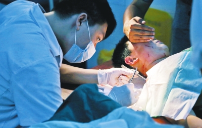 孩子身上有7道傷痕，其中兩道需要縫合，其他的均為擦傷，醫(yī)生正對(duì)他施治。