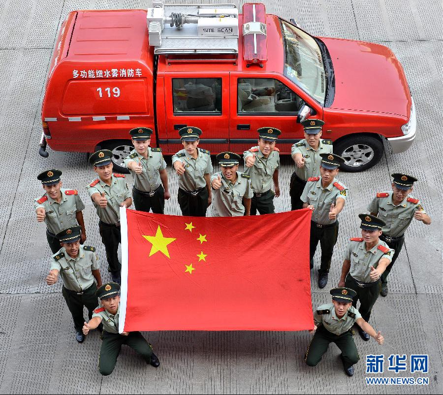  9月25日，武警浙江嘉興消防官兵與國旗合影。
