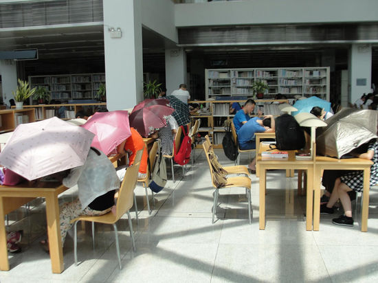 圖書館內(nèi)撐傘讀書的民眾。