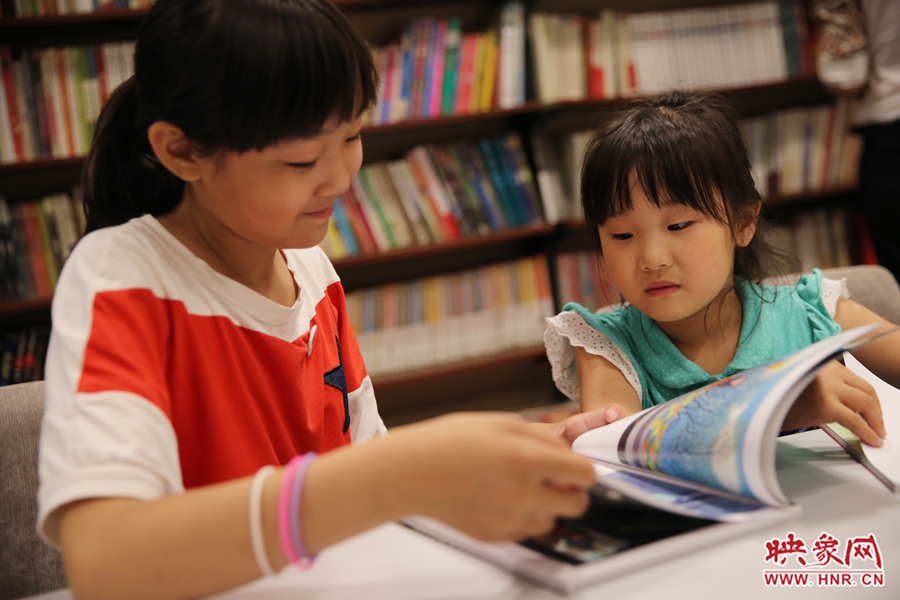 姐姐王藝茹，11歲，小學(xué)五年級學(xué)生；妹妹王有君，5歲：像喜歡看電視一樣喜歡看書。